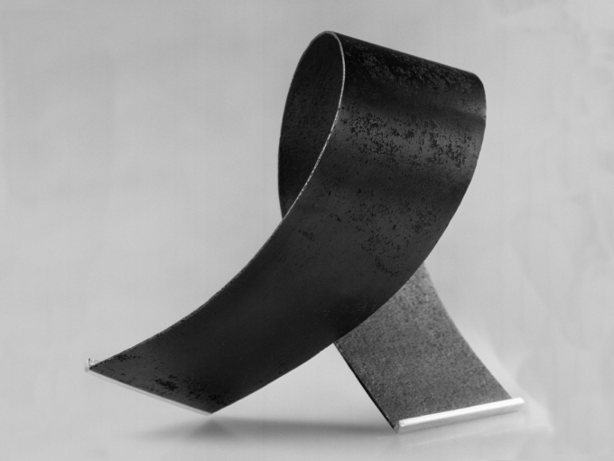 Metall er Tone Vigelands foretrukne materiale, og arbeidene kombinerer gjerne det harde materialet med myke former og ulike teksturer. Her armbånd i stål og sølv fra 1985. Foto: Hans-Jørgen Abel.